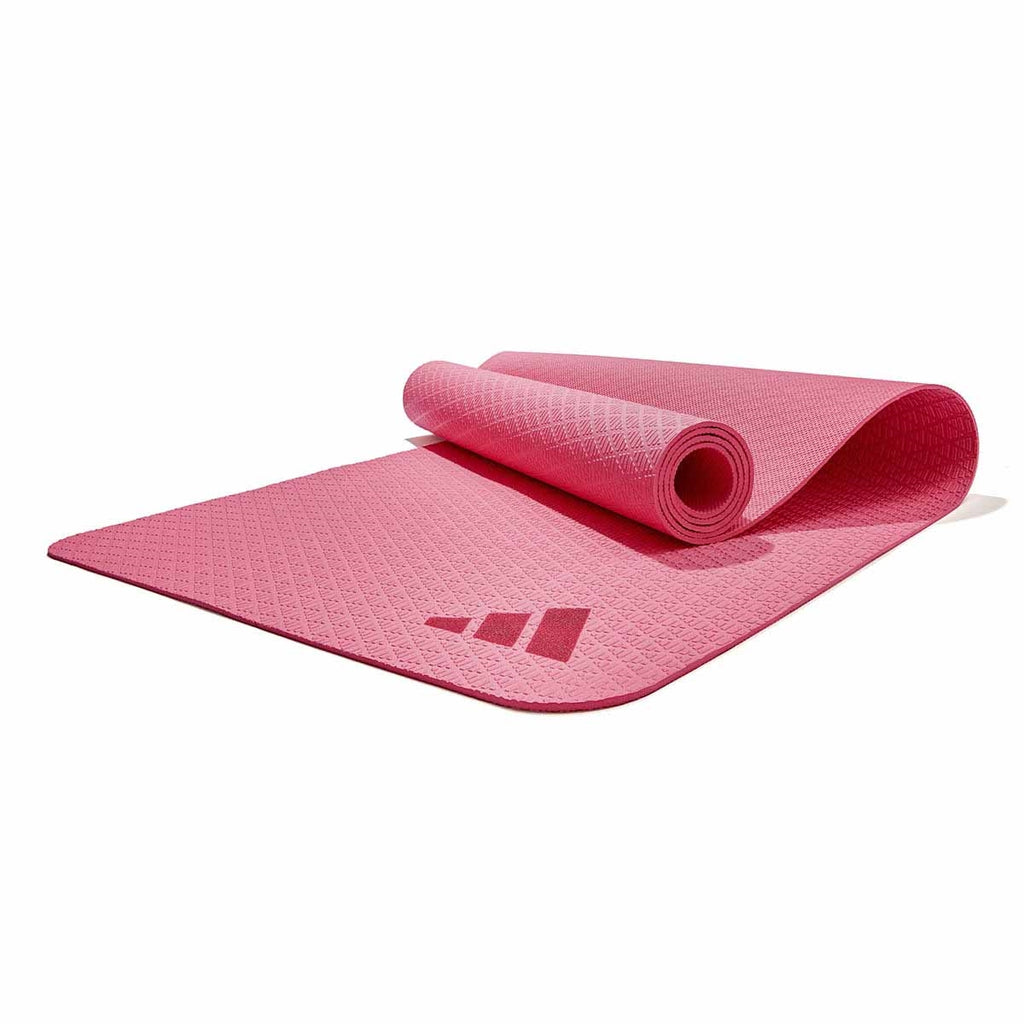 Pink yoga mat with Adidas logo on a white background